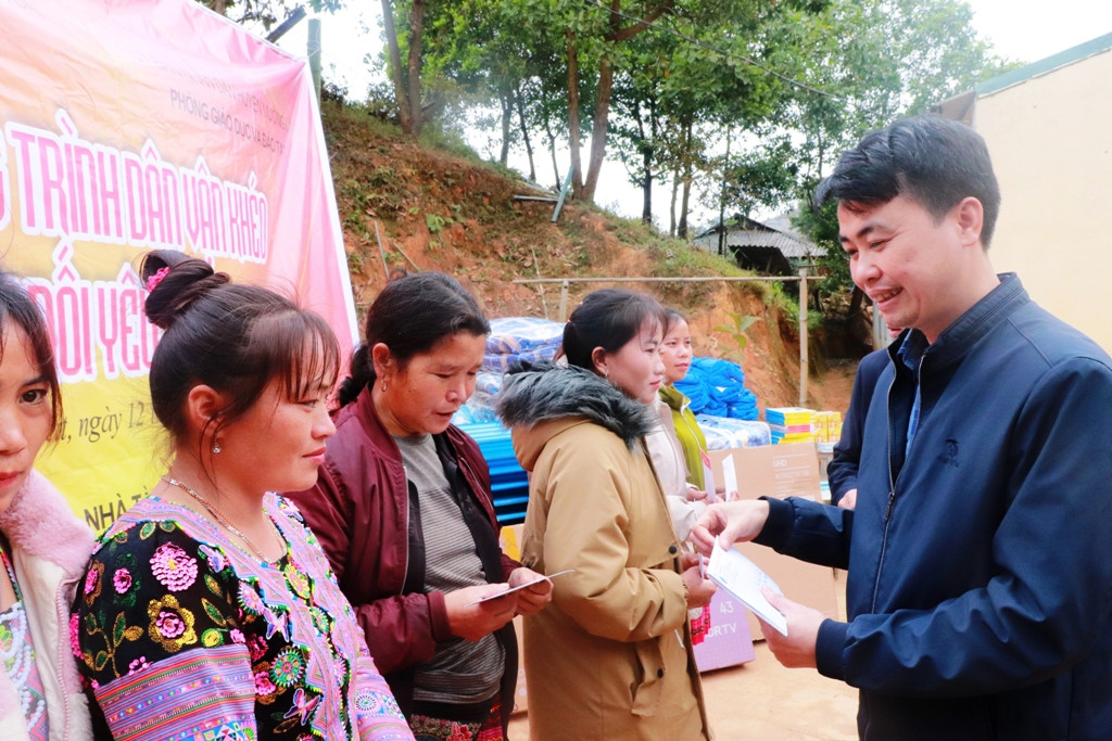 Ông Lê Trung Kiên - Phó Chánh Văn phòng Huyện ủy Mường Lát trao học bổng cho phụ huynh nhận thay học sinh. Ảnh: Đăng Chung
