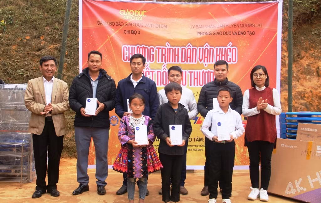 Nhà báo Trần Thị Ngọc Nam - Chủ tịch Công đoàn Báo GD&TĐ và ông Tống Minh Tới - Phó Trưởng phòng GD&ĐT Mường Lát (ngoài cùng bên trái) trao máy tính bảng cho giáo viên và học sinh. Ảnh: TL