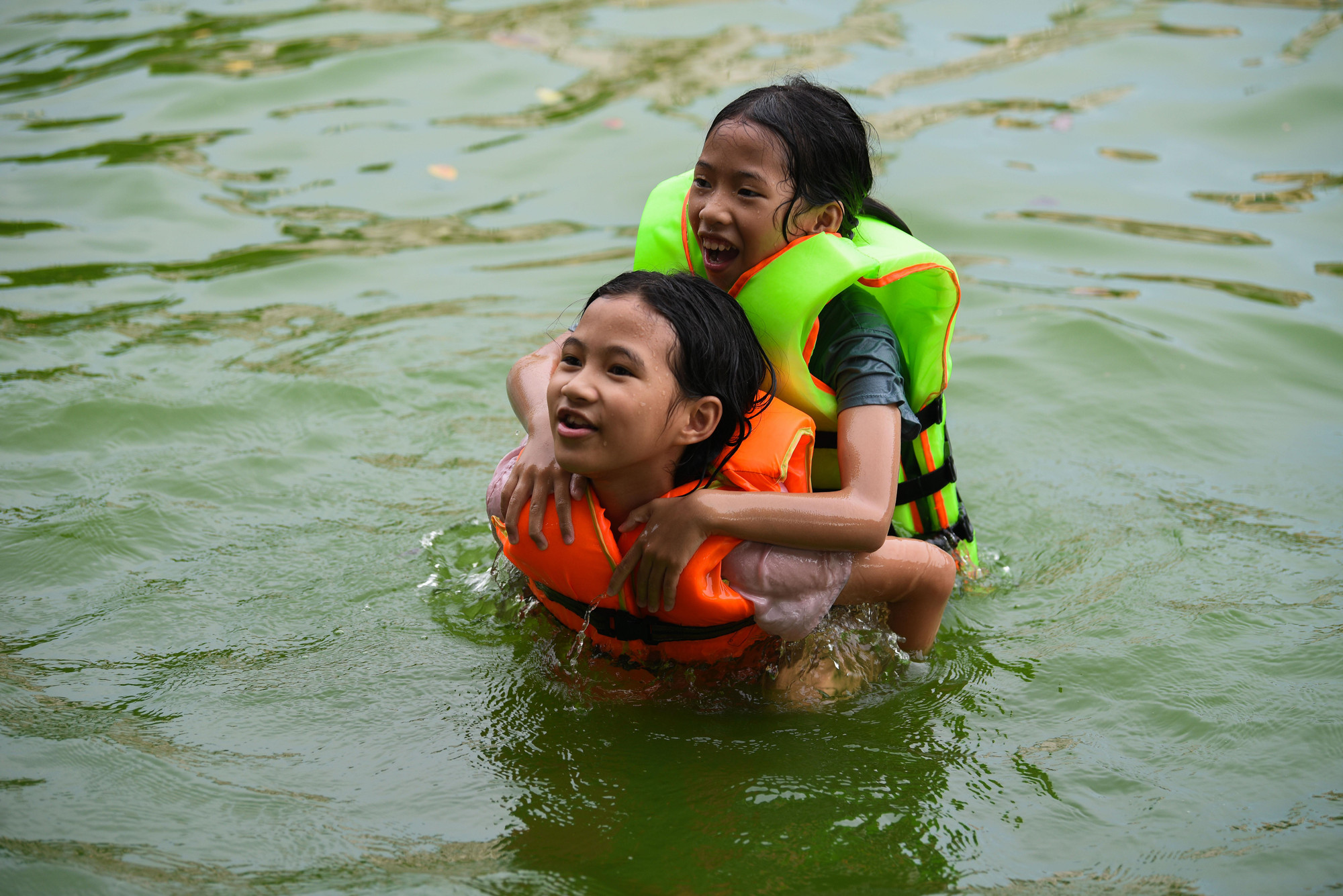 Ở đây, trẻ em được phụ huynh dẫn đi tắm mát, lứa tuổi dao động từ 5-15 tuổi. Các em nhỏ dưới 10 tuổi được bố mẹ sắm áo phao đầy đủ.
