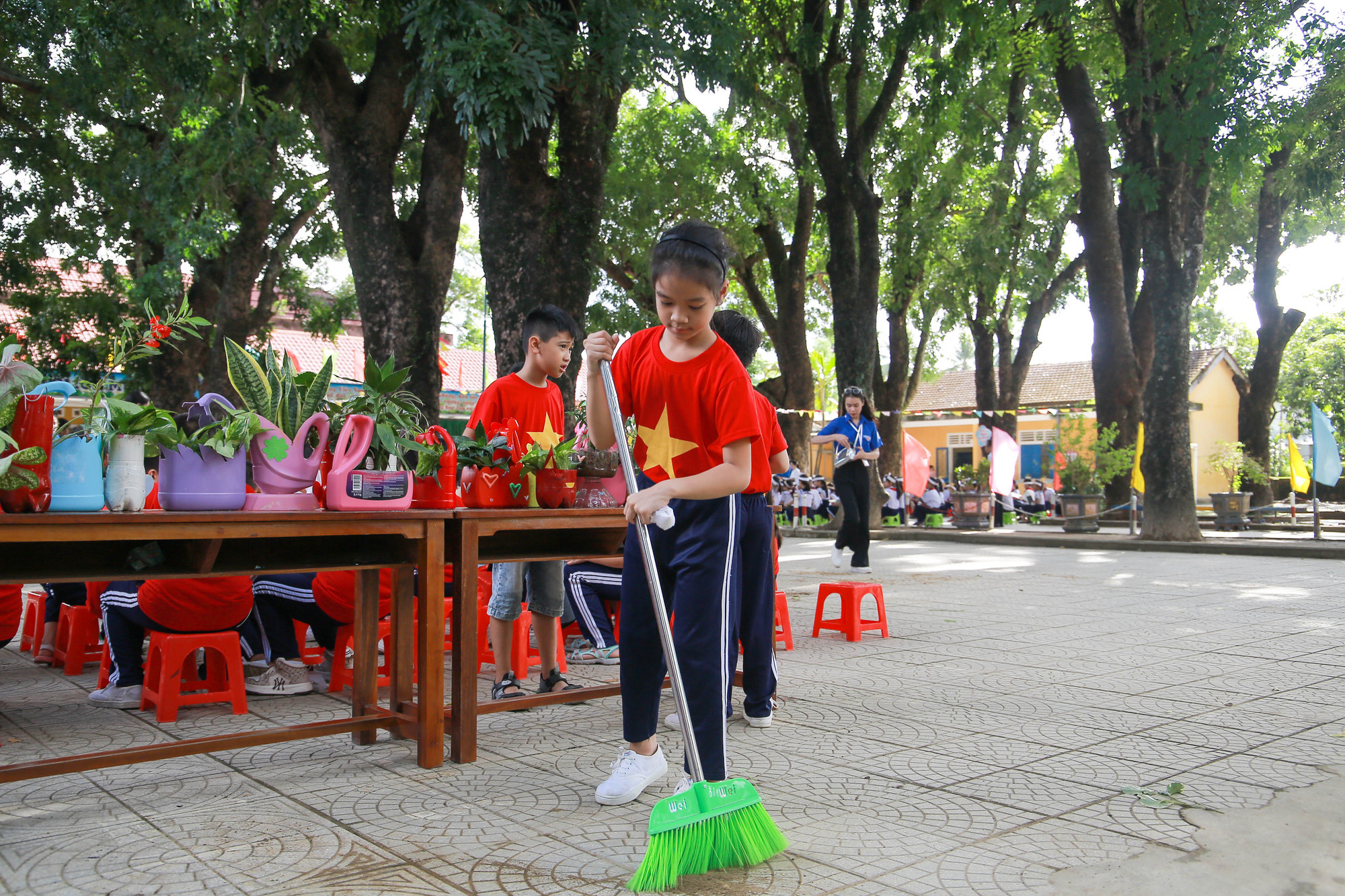 Dọn dẹp sạch sẽ sân trường khi trồng xong cây.