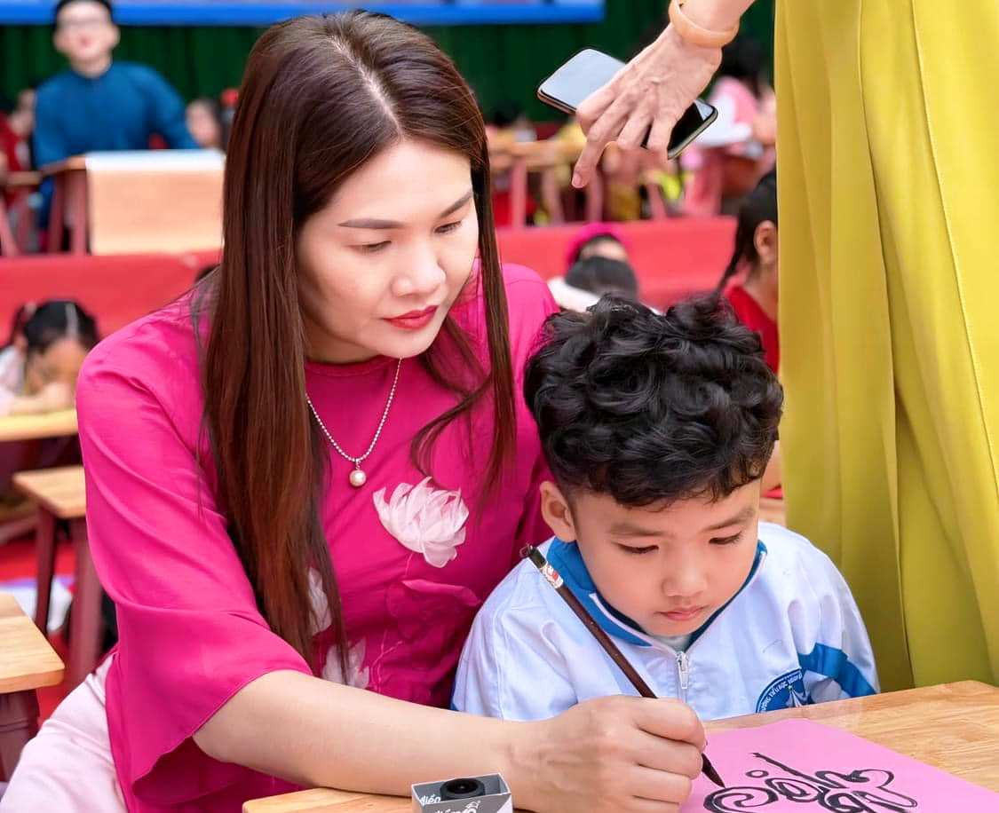 Cô giáo hướng dẫn học trò viết chữ thư pháp. Ảnh: MH Cô giáo hướng dẫn học trò viết chữ thư pháp. Ảnh: MH