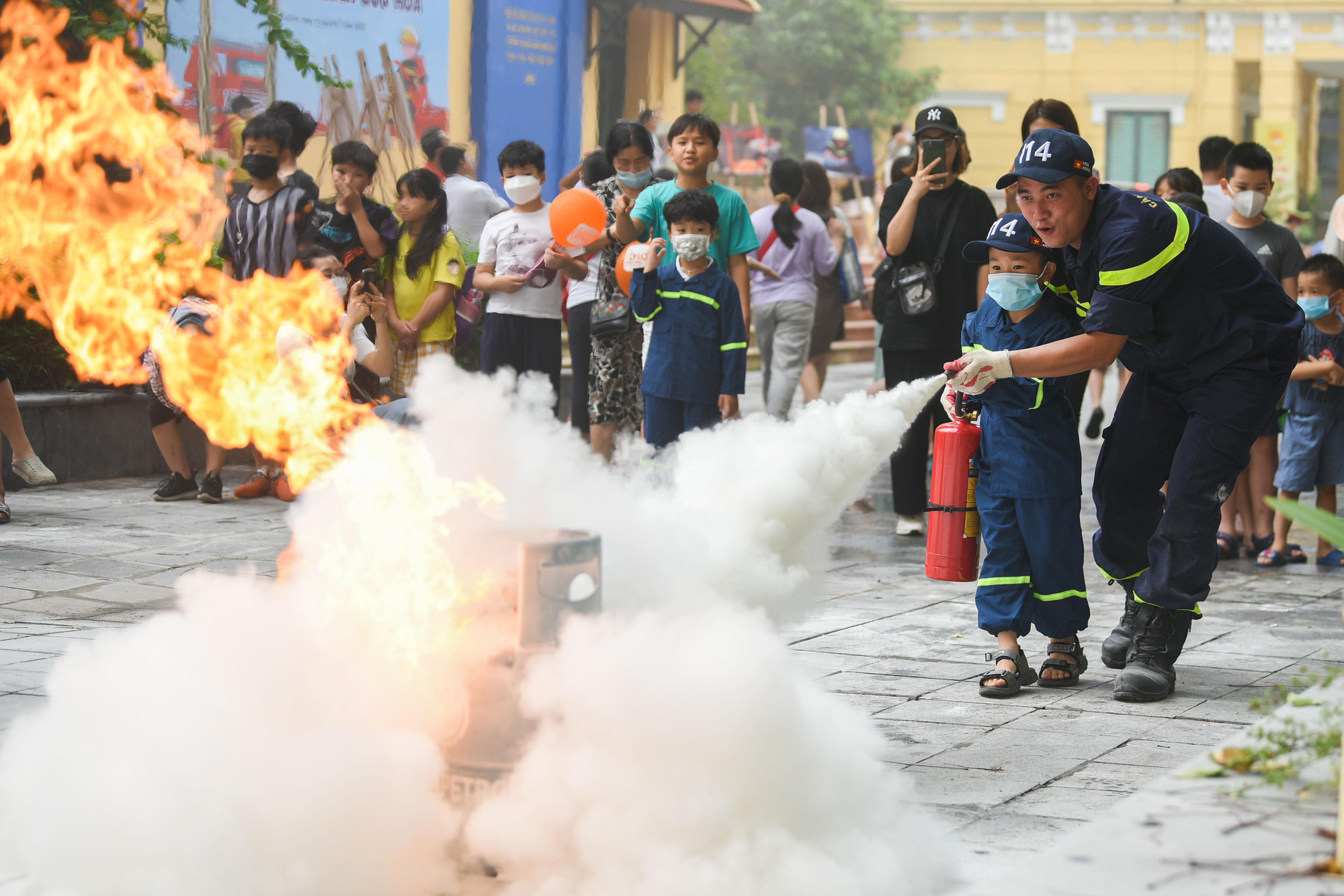 Các em học sinh được trải nghiệm hoạt động mặc trang phụ chữa cháy chuyên dụng tham gia trò chơi &apos;chạy qua cọc lửa&apos;.