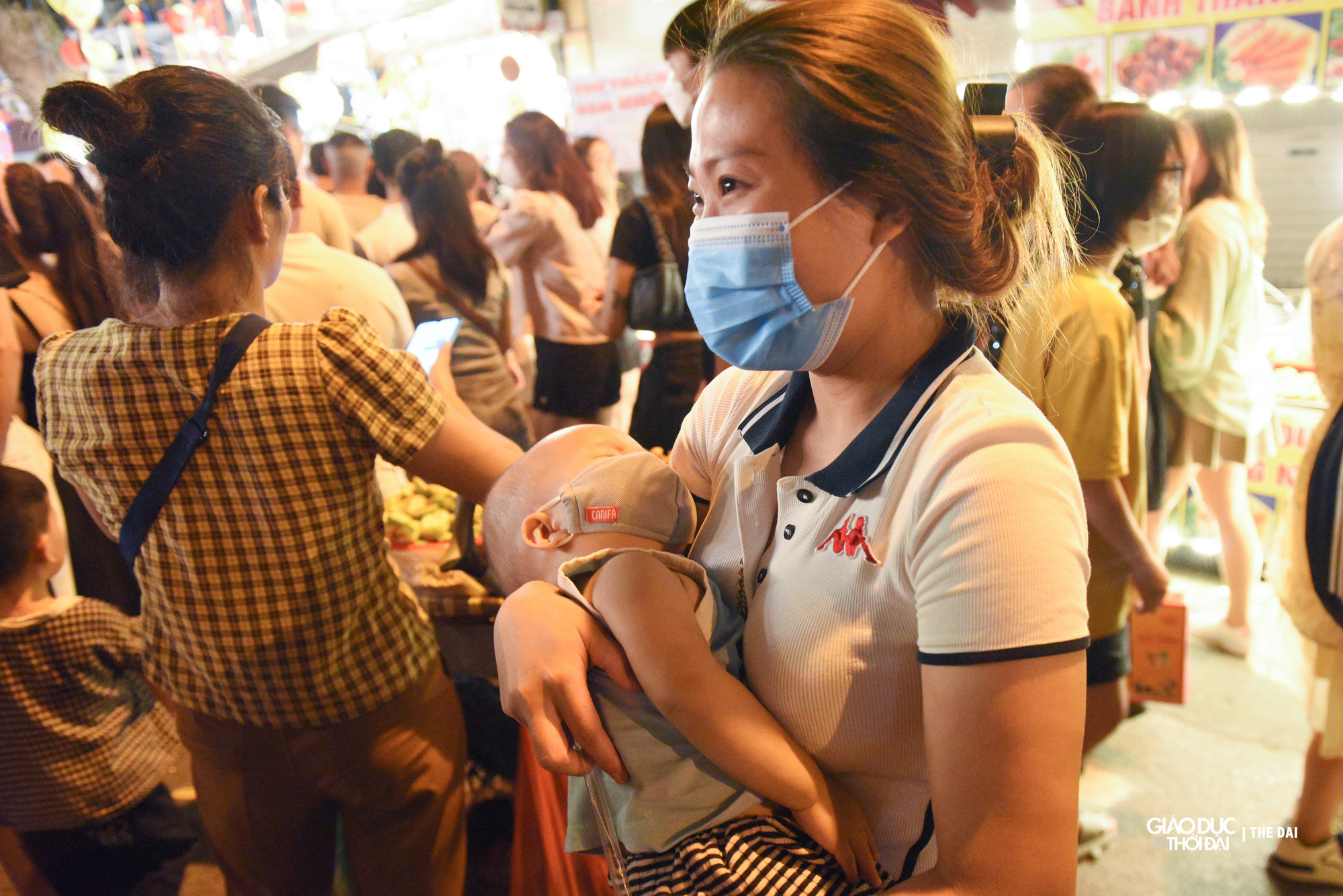 Nhiều bạn nhỏ đã ngủ trên tay cha mẹ khi di chuyển trên con phố Hàng Mã.
