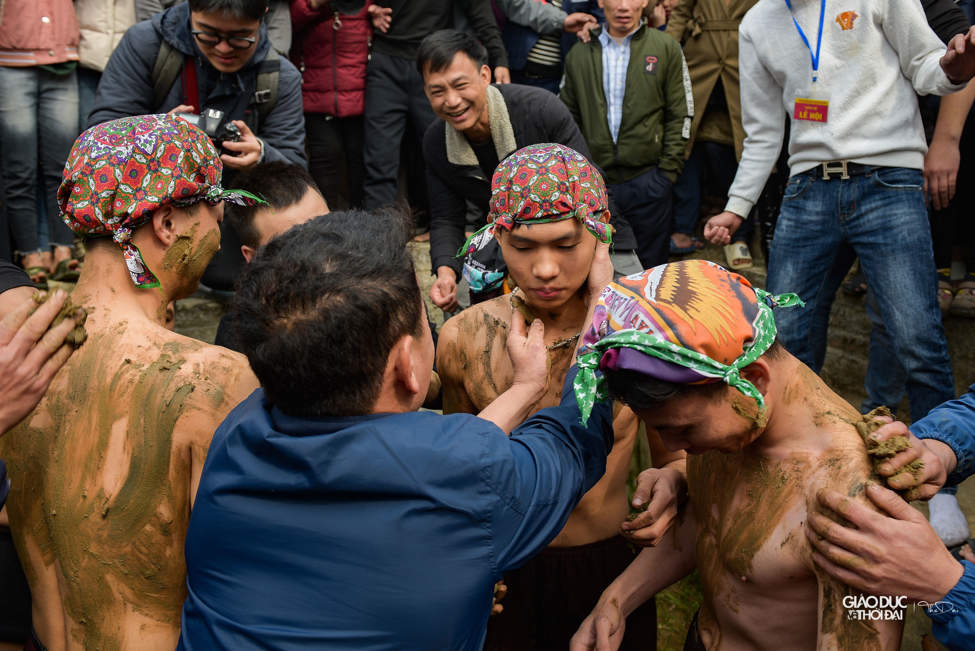Lúc này không khí vô cùng sôi động, hàng trăm thanh niên hộ tống 3 ông Bụt đi ra đồng trát bùn.