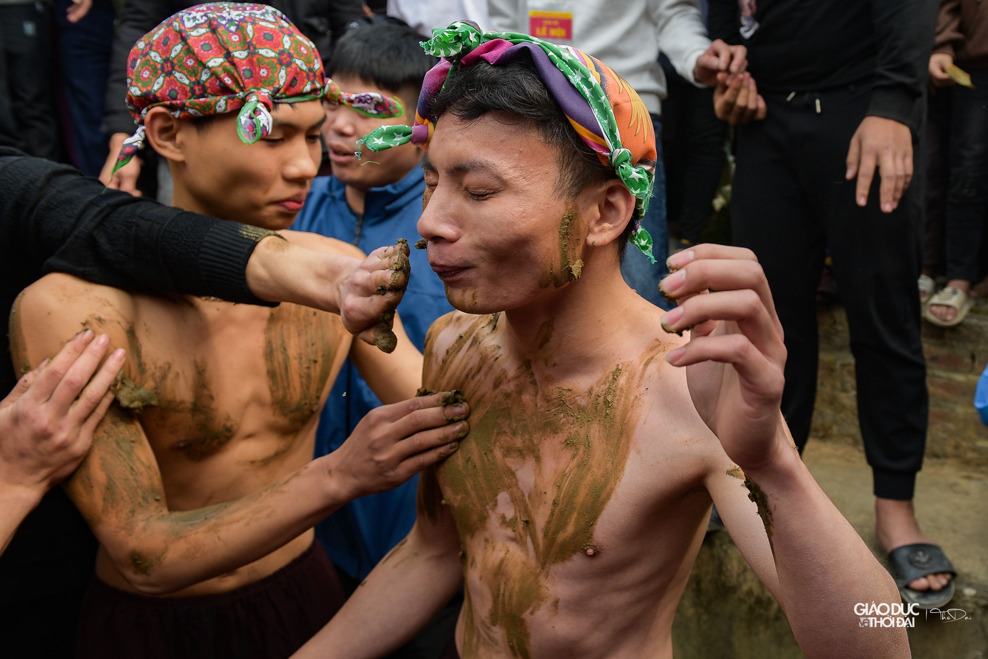Lúc này không khí vô cùng sôi động, hàng trăm thanh niên hộ tống 3 ông Bụt đi ra đồng trát bùn.