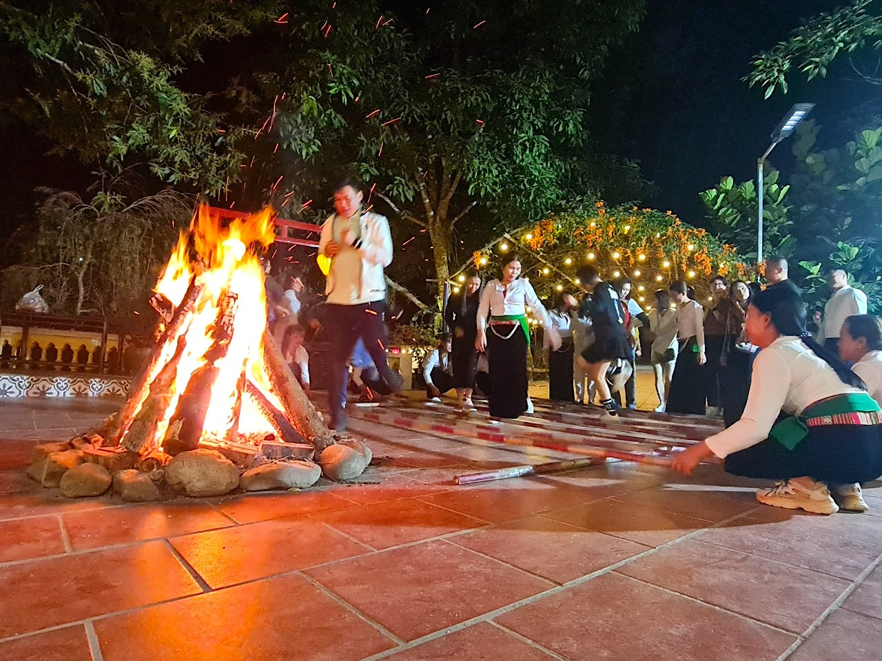 Trong không khí se lạnh về đêm, mọi người ngồi quây quần đốt lửa trại, uống rượu cần, giao lưu múa sạp với người dân bên ánh lửa bập bùng.