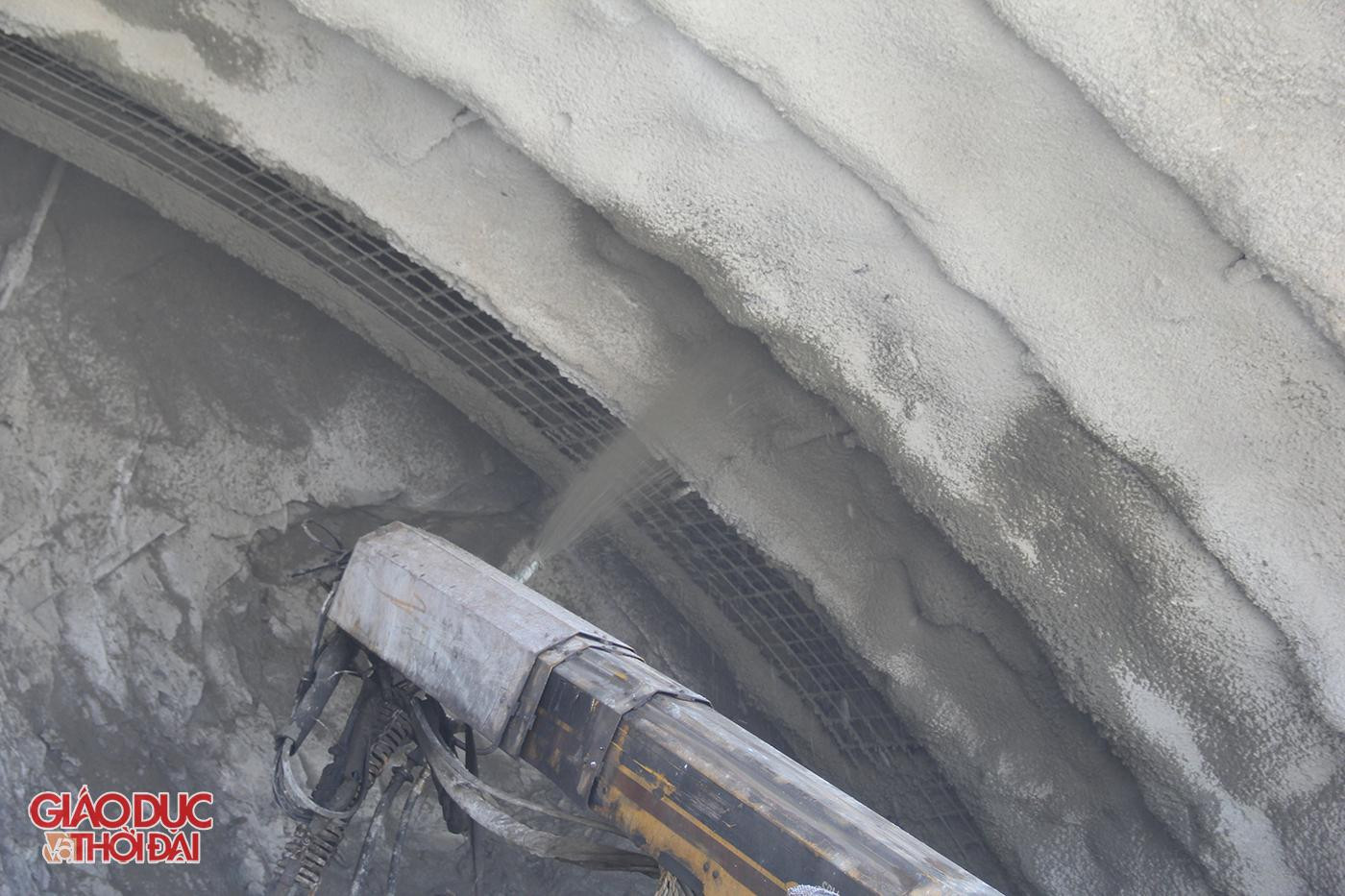 Sau khi máy móc đào đất đá trong núi, công nhân sẽ dọn đất đá ra ngoài rồi ghim một lớp thép trên nóc hầm, đặt miếng đệm sắt, siết chặt đai ốc để làm kết cấu chống đỡ. Mái hầm thi công đến đâu sẽ được phun bê tông tươi gia cố chắc đến đó.