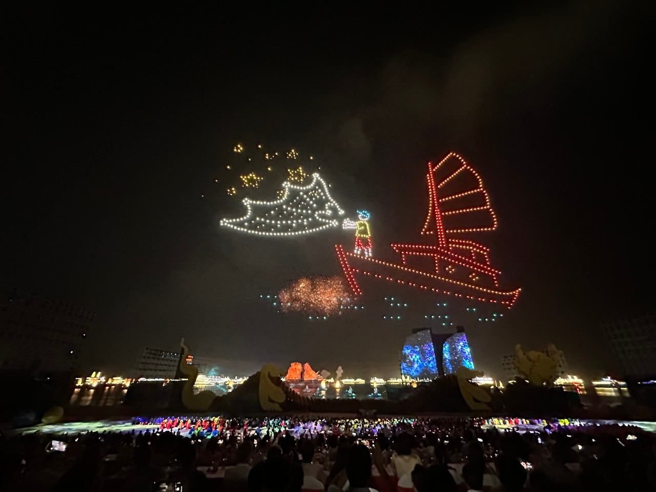 Hình ảnh chiếc thuyền đánh cá với người ngư dân tung lưới bắt lấy những vì sao và màn pháo hoa rực rỡ.