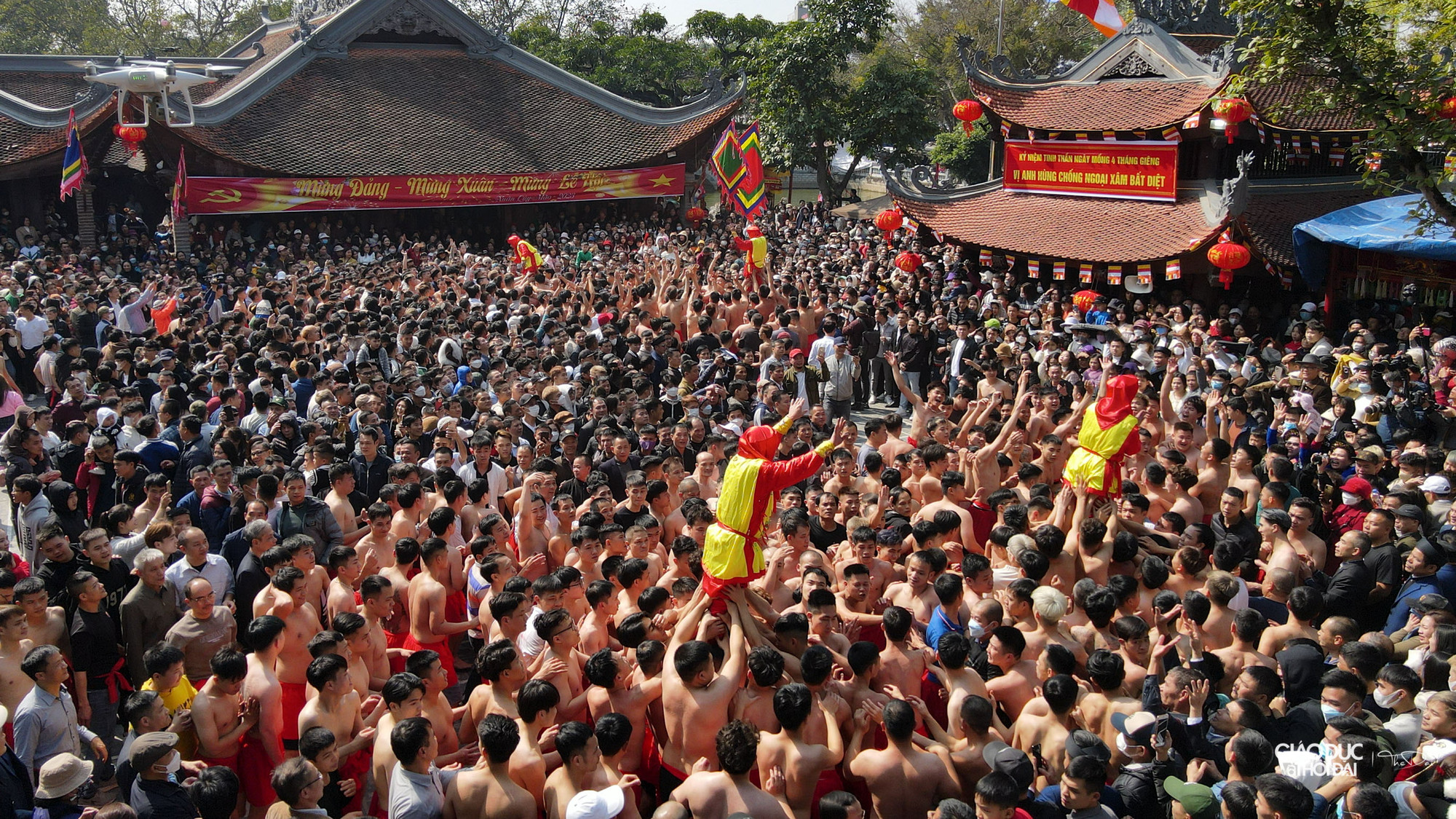 Họ được các thanh niên cởi trần, mặc quần đùi đỏ tung hô và giữ chắc ở trên cao.