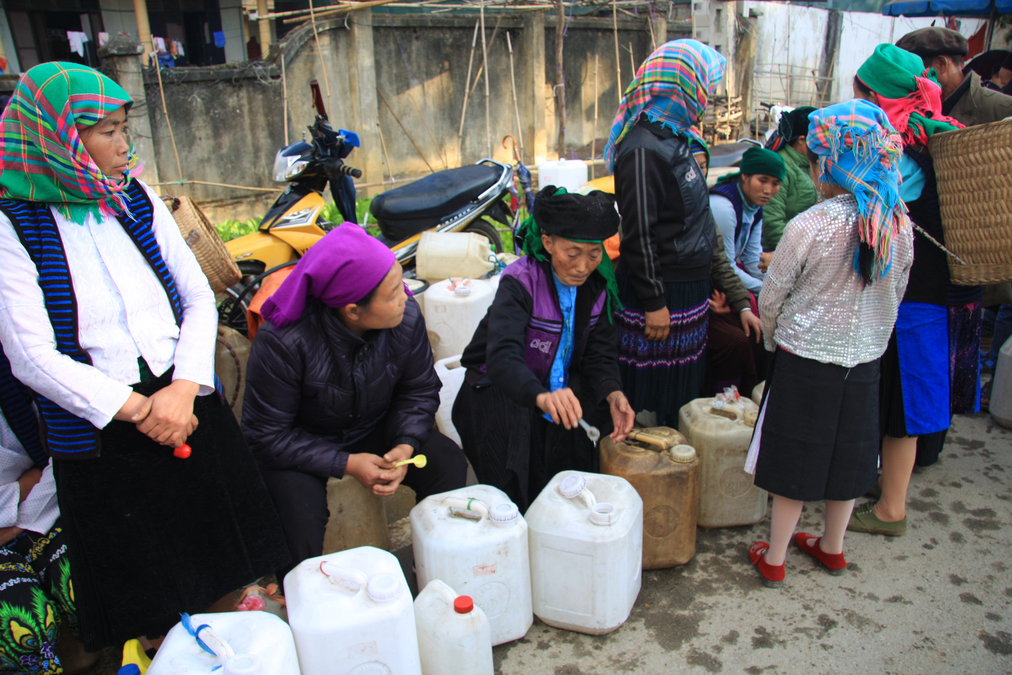 Nét độc đáo, thú vị là một hàng dài phụ nữ đứng bán rượu ngô, sẵn sàng cho người đi chơi chợ phiên múc rượu uống thử.