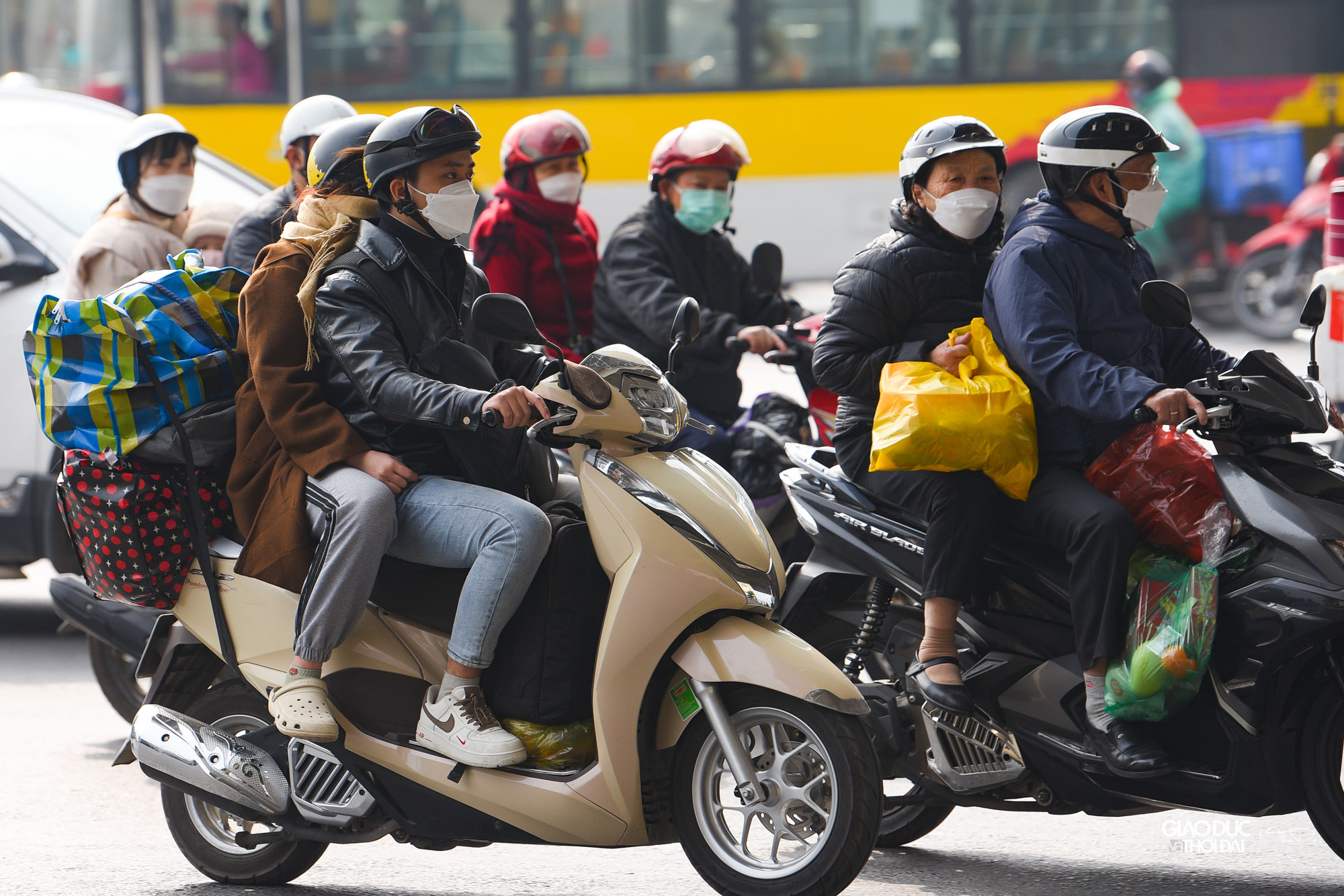 Nhiều người dân lựa chọn xe máy để di chuyển, đằng sau lỉnh kỉnh đồ đạc mang từ quê nhà.