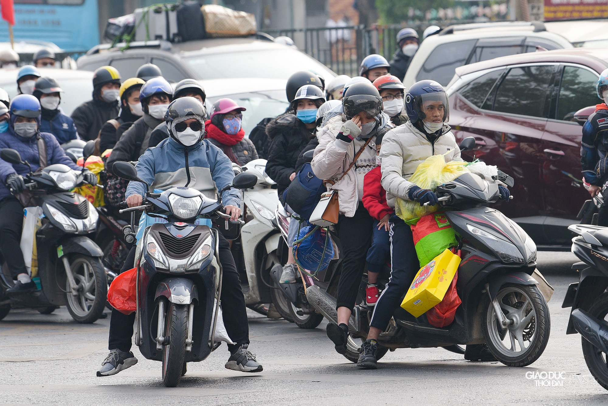 Nhiều người dân lựa chọn xe máy để di chuyển, đằng sau lỉnh kỉnh đồ đạc mang từ quê nhà.