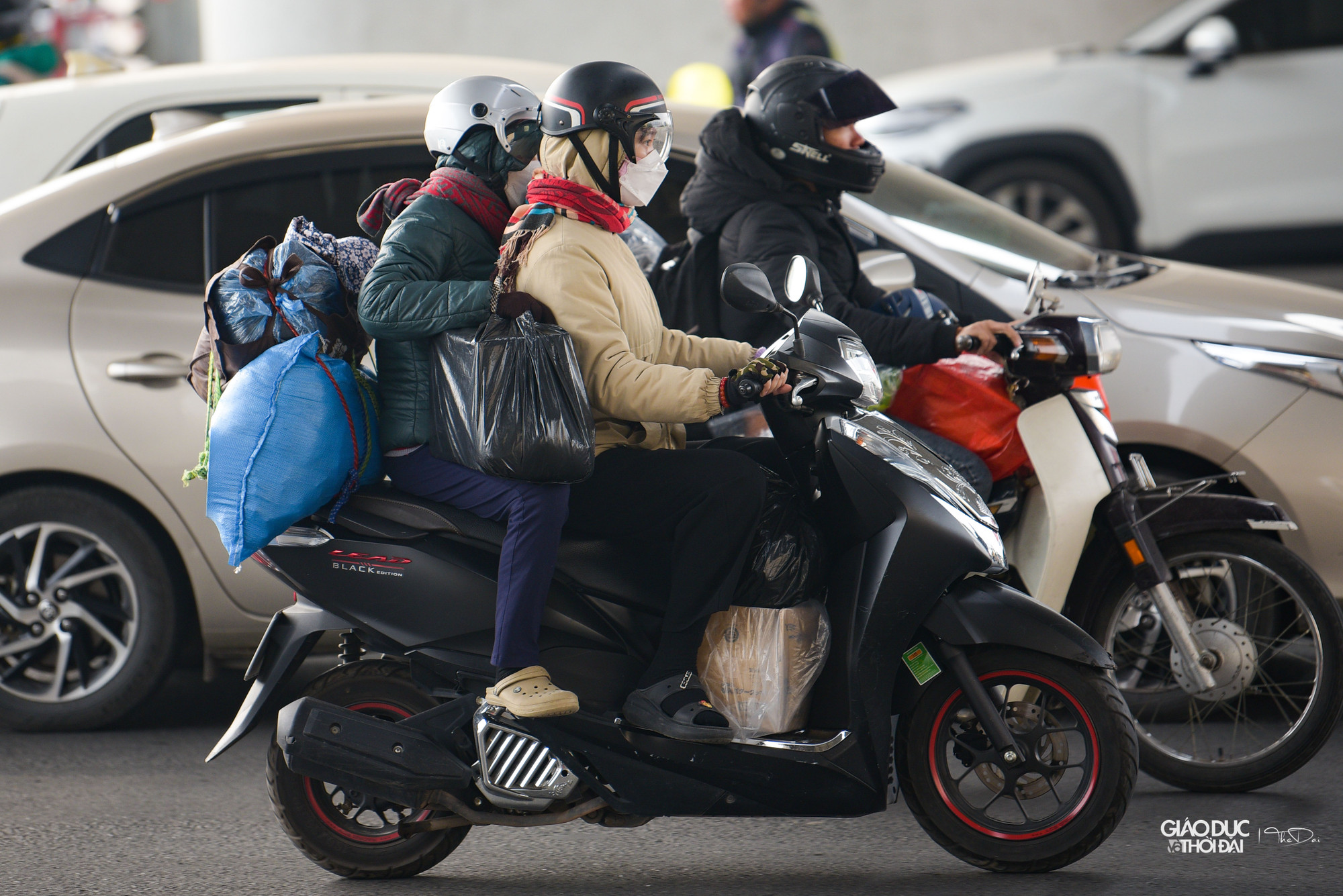 Nhiều người dân lựa chọn xe máy để di chuyển, đằng sau lỉnh kỉnh đồ đạc mang từ quê nhà.