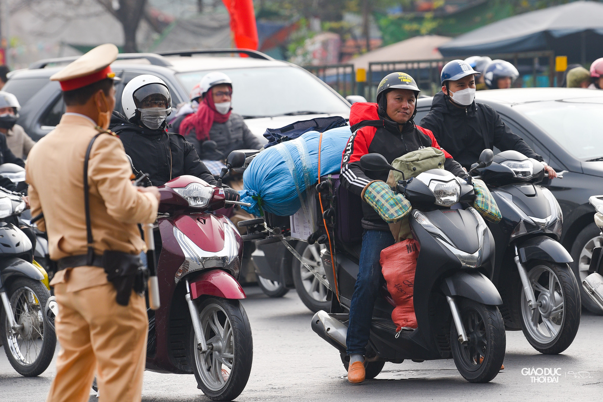 Nhiều người dân lựa chọn xe máy để di chuyển, đằng sau lỉnh kỉnh đồ đạc mang từ quê nhà.
