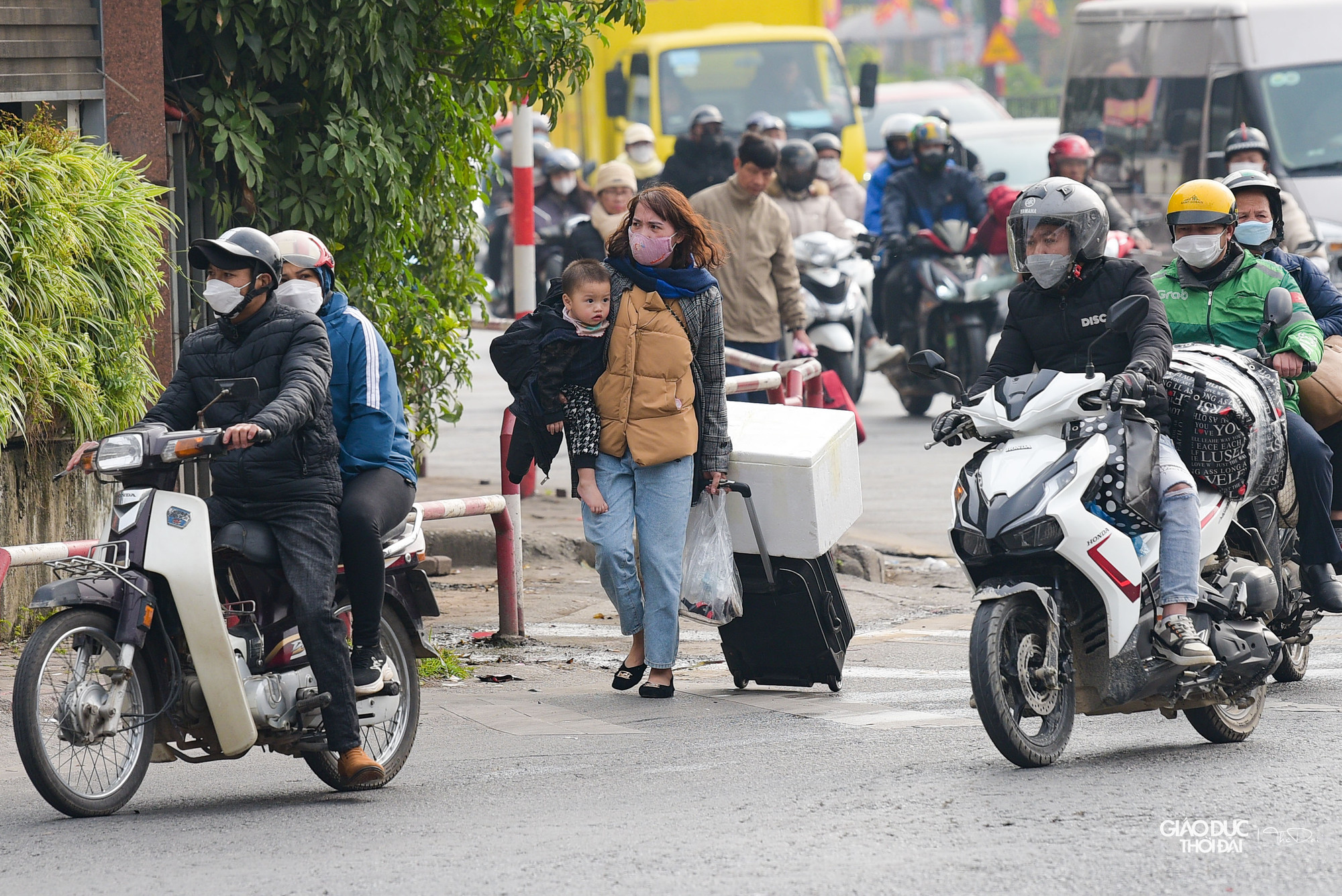 Vừa bế con, vừa kéo đồ đi ra khỏi bến xe.