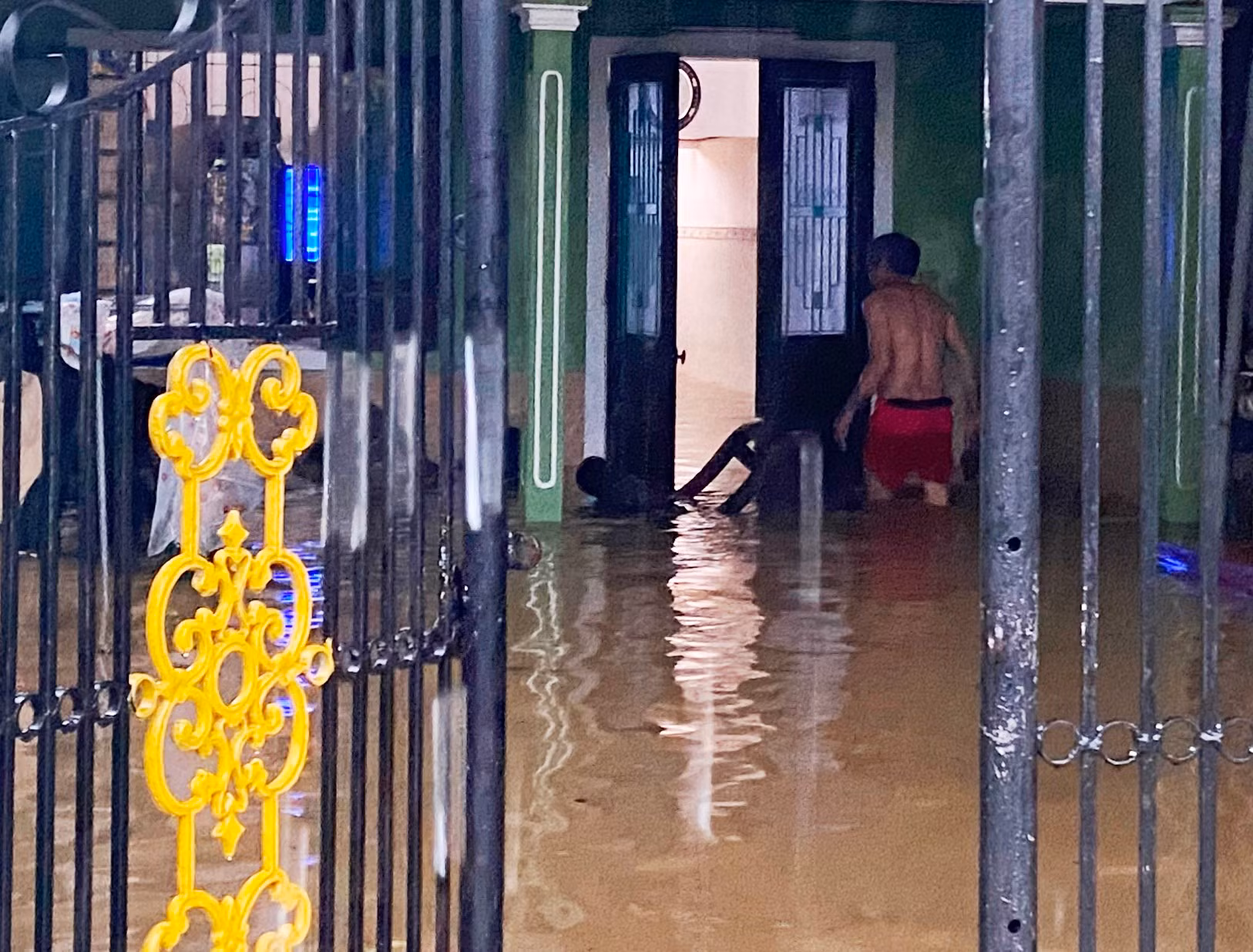 Một hộ dân tại đường này phải vất vả đi dọn đồ, đưa lên nơi cao khi nước ngày càng dâng.