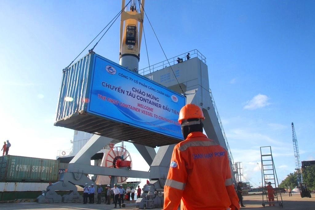 Thùng container đầu tiên được cần cẩu cực lớn từ cầu cảng trục xuống chân cầu cảng.