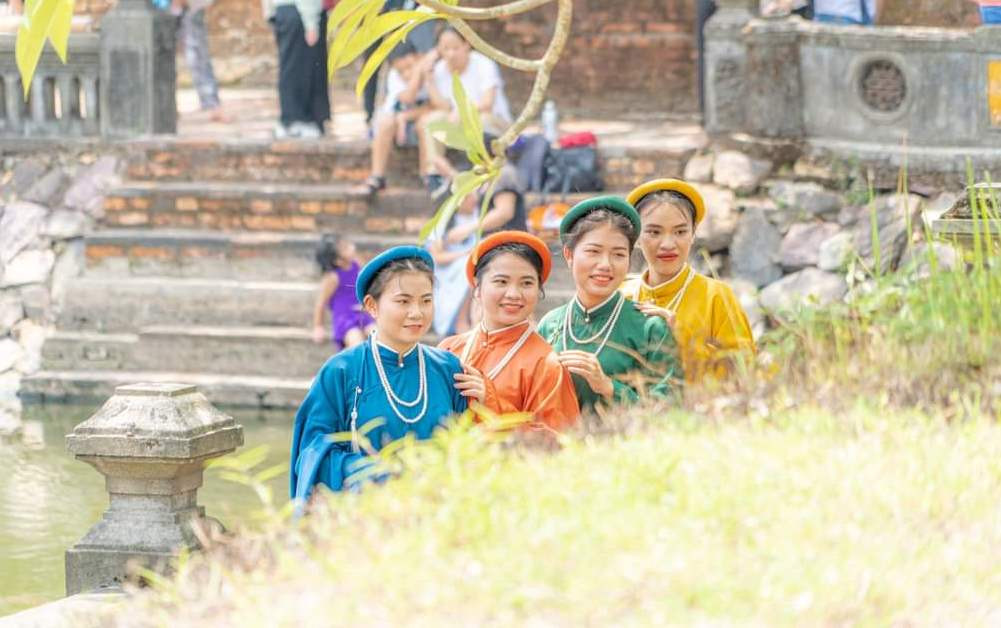 Một nhóm du khách chụp hình với áo dài cổ phục.