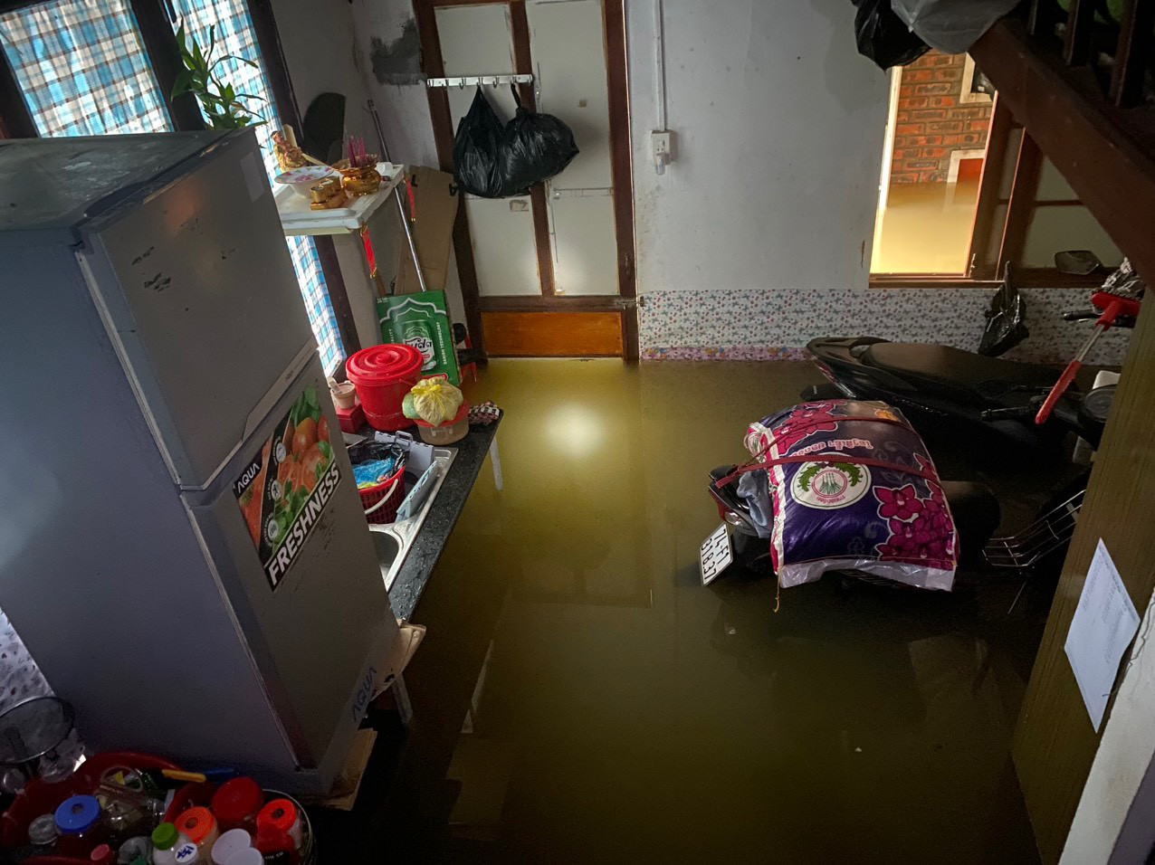 Một nhà trọ phải chồng đồ đạc, tủ lạnh lên cao nhưng xe vẫn bị ngập.