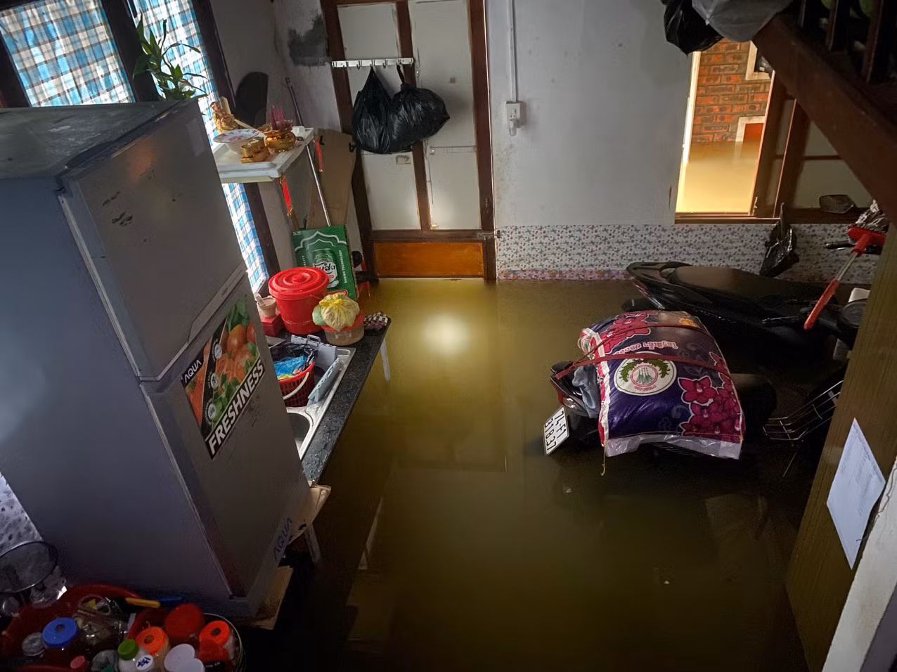 Một nhà trọ phải chồng đồ đạc, tủ lạnh lên cao nhưng xe vẫn bị ngập.