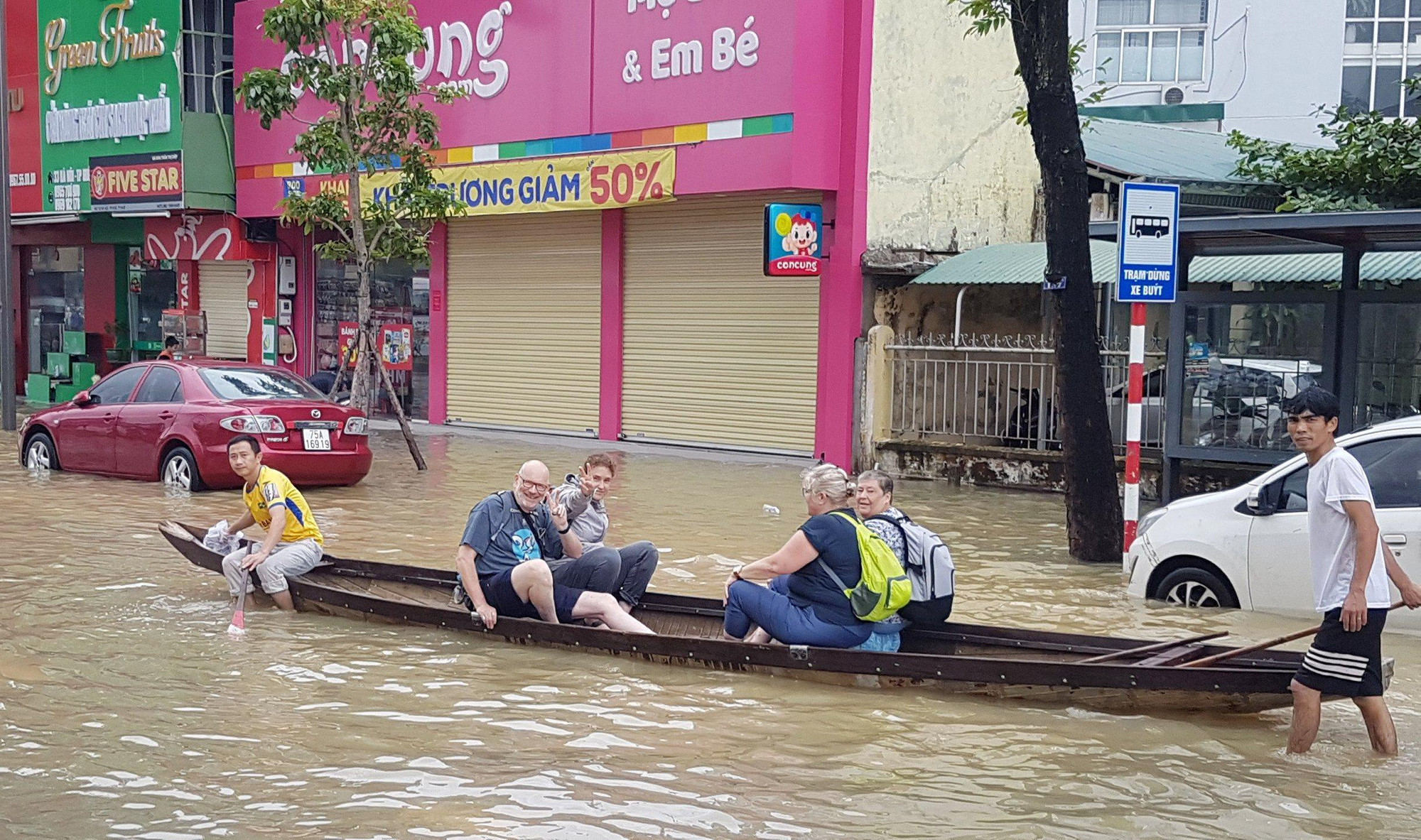 Một đoàn khách du lịch trải nghiệm đi ghe nhìn cảnh nước lụt trên đường phố. Một đoàn khách du lịch trải nghiệm đi ghe nhìn cảnh nước lụt trên đường phố.