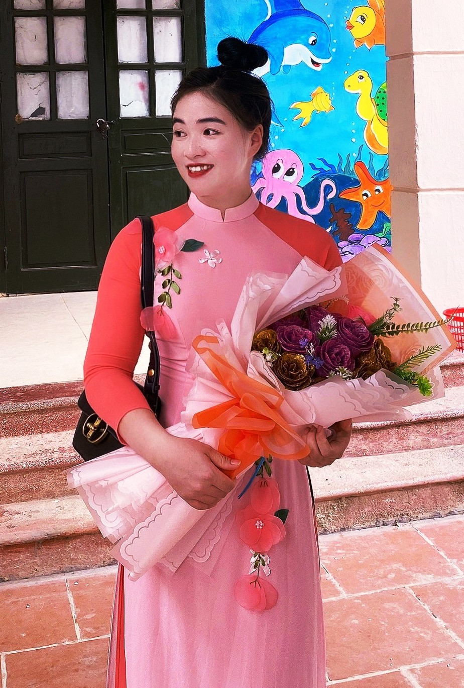Cô giáo Hậu trong tà áo dài truyền thống và hoa. Ảnh: NVCC