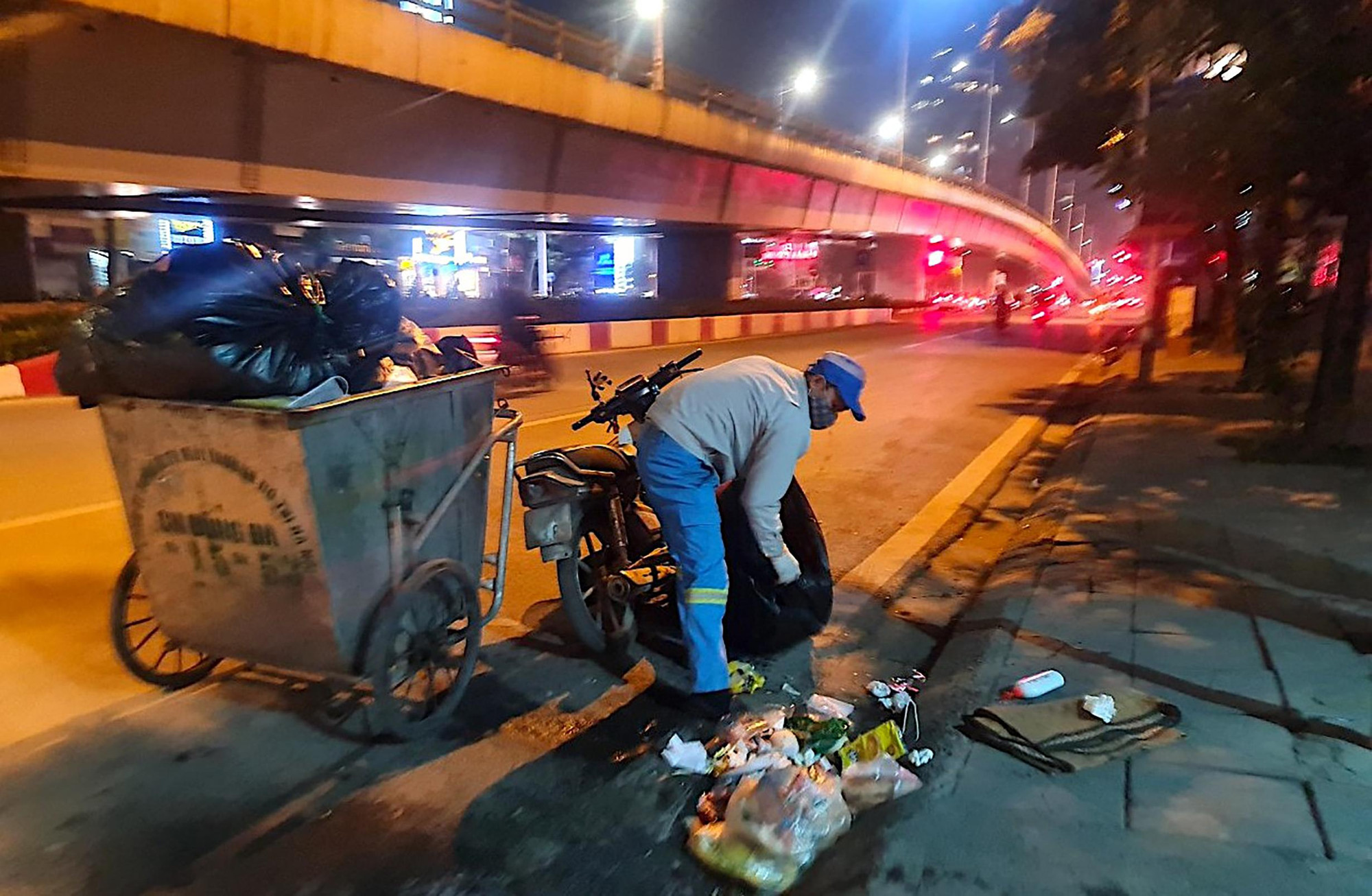 Hình ảnh công nhân môi trường miệt mài thu dọn vệ sinh làm sạch đẹp phố phường trên đường vành đai 3 Khuất Duy Tiến (Hà Nội) trong đêm là một nét đẹp ấn tượng giữa mùa đông giá lạnh.