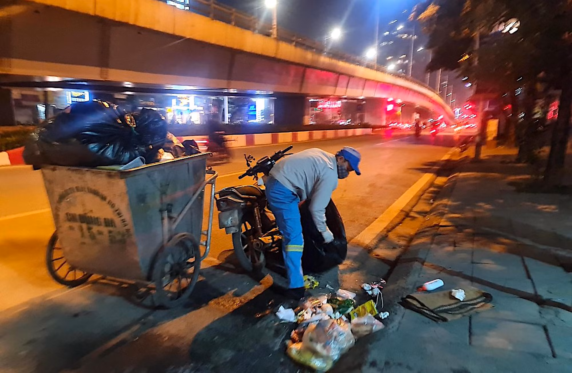 Hình ảnh công nhân môi trường miệt mài thu dọn vệ sinh làm sạch đẹp phố phường trên đường vành đai 3 Khuất Duy Tiến (Hà Nội) trong đêm là một nét đẹp ấn tượng giữa mùa đông giá lạnh.
