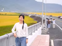 Chị Như Ngọc tạo dáng bên cung đường uốn lượn giữa đồng ruộng và núi non.