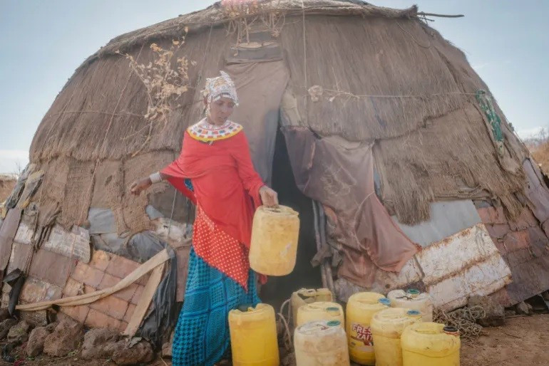 Dukano Kelle đang gom can nhựa để lấy nước ở Kambinye, Kenya. Ảnh: Fredrik Lerneryd/Oxfam. kenya-tao-hon-2.jpg