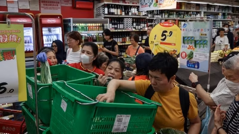 Người dân Hồng Kông tích trữ nhu yếu phẩm tại một siêu thị ngày 22/9. Các quan chức trong khu vực đã công bố một loạt các biện pháp khẩn cấp, bao gồm đóng cửa trường học và tạm dừng giao thông. - Ảnh: Tyrone Siu/Reuters