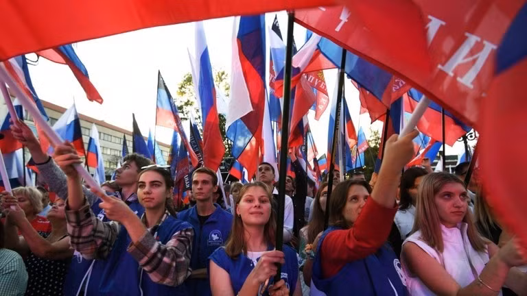 Người dân giương cao cờ Nga tại một cuộc biểu tình ở Simferopol, Nga, để ủng hộ việc sáp nhập các vùng Donetsk, Lugansk, Kherson và Zaporozhye vào Nga ngày 30/9/2022. Ảnh: © Konstantin Mikhalchevsky / Sputnik