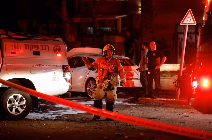 Một lính cứu hỏa đứng tại hiện trường sau khi rocket bắn từ dải Gaza về phía Israel, tại Ashkelon, Israel ngày 6/4. Ảnh: REUTERS