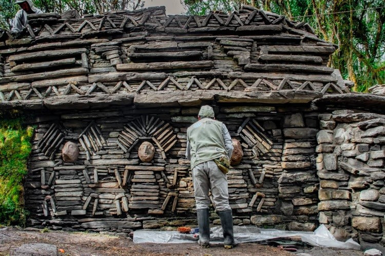 Một nhà nghiên cứu của Quỹ Di tích Thế giới đang kiểm tra các tác phẩm điêu khắc phù điêu ở bên ngoài một công trình tại địa điểm Gran Pajaten trong chuyến thám hiểm năm 2024. phat-hien-chan-dong-100-kien-truc-co-an-minh-suot-hang-the-ky-o-andes.jpg