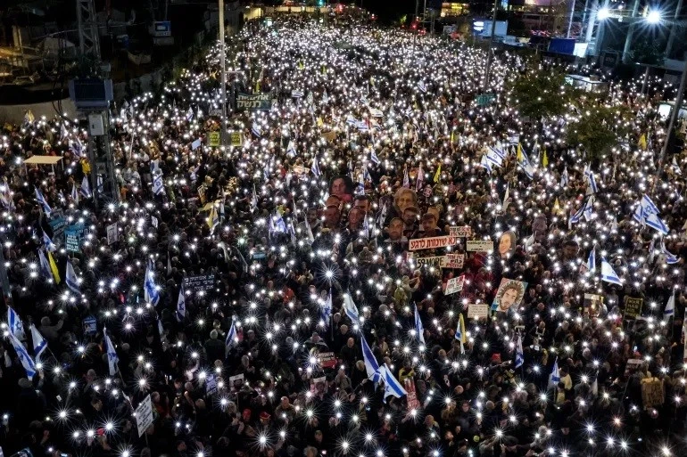 Hàng ngàn người tụ tập bên ngoài trụ sở Bộ Quốc phòng Israel tại Tel Aviv vào đêm 22/3 khi nội các chiến tranh của Israel họp để thảo luận về các cuộc tấn công mới vào Dải Gaza [Ảnh: Jack Guez/AFP]