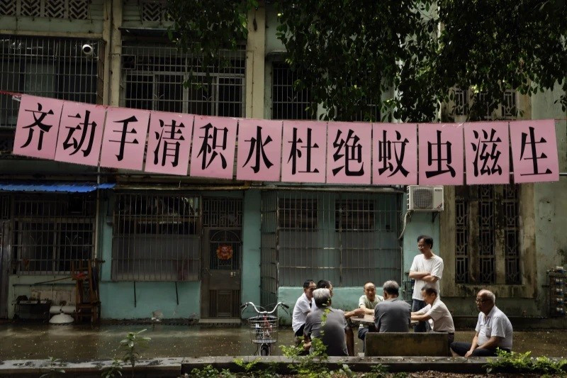 Người dân dưới biểu ngữ kêu gọi diệt muỗi treo tại một khu dân cư ở Quảng Châu, tỉnh Quảng Đông, miền nam Trung Quốc, ngày 6/8. (Ảnh: Chinatopix qua AP) muoi-mang-virus-khien-7000-nguoi-nhiem-trung-quoc-trien-khai-uav-de-ngan-chan.jpg