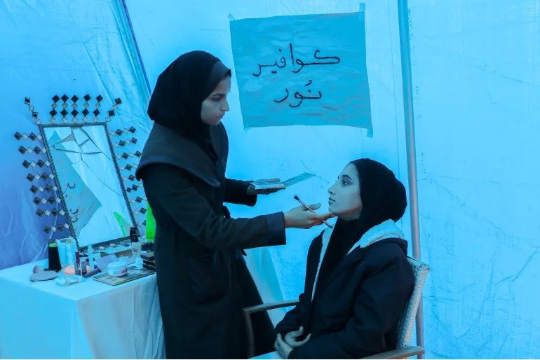 Noor trang điểm cho Aya để đi đám cưới. Ảnh: Abdelhakim Abu Riash, Al Jazeera. lam-dep-o-gaza-4.jpg