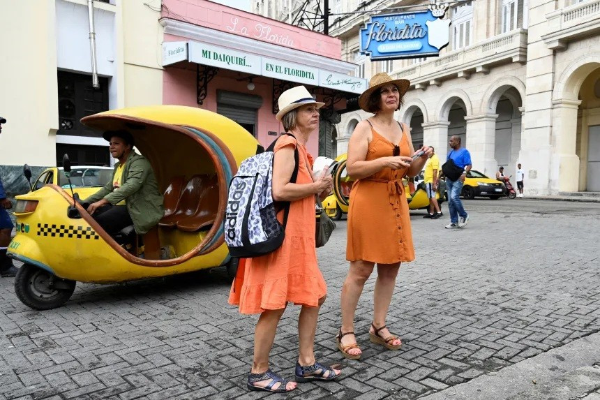 Du khách đi bộ dọc theo một con phố ở Havana. Ảnh: Yamil Lage/AFP rac-ngap-cup-dien-va-thieu-nuoc-o-cuba-4.jpg