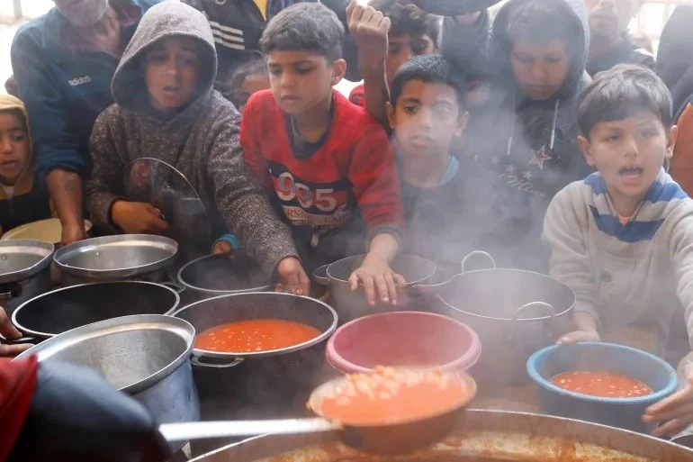 Trẻ em Palestine chờ nhận đồ ăn do bếp ăn từ thiện nấu trong tháng lễ Ramadan của người Hồi giáo tại Khan Younis, phía Nam Dải Gaza, ngày 9/3. Ảnh: Hatem Khaled/Reuters.