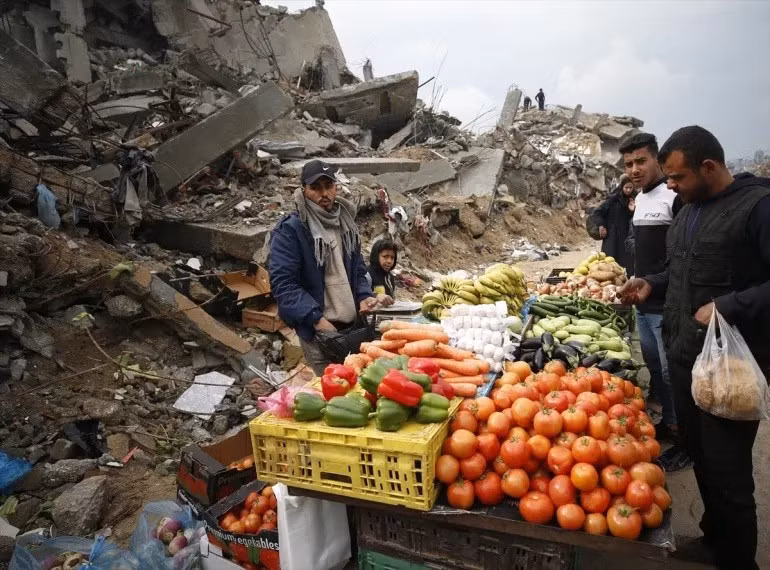 Một nhóm người Palestine dựng một khu chợ nhỏ giữa đống đổ nát của những tòa nhà bị phá hủy tại trại tị nạn Jabalia ở Gaza. Ảnh: Mahmoud İssa/Anadolu.
