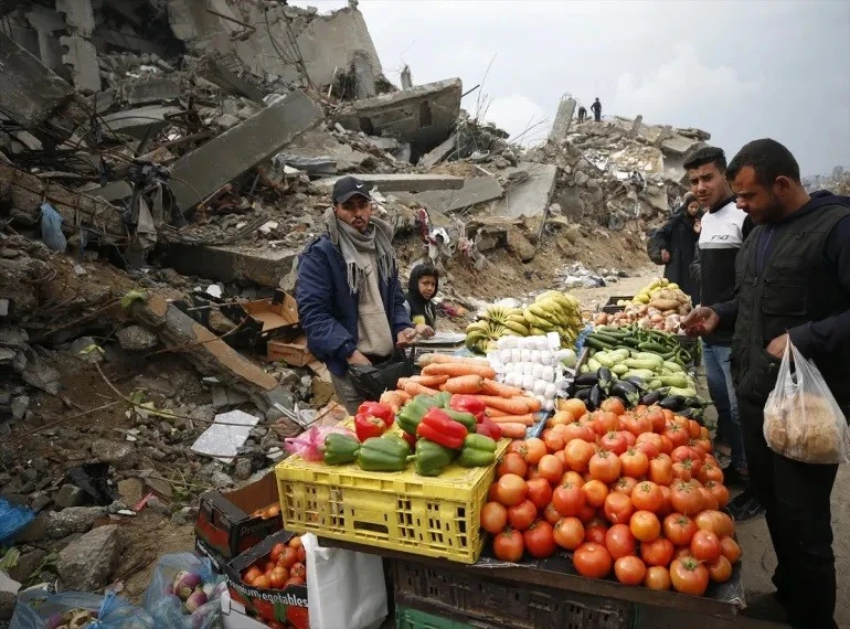 Một nhóm người Palestine dựng một khu chợ nhỏ giữa đống đổ nát của những tòa nhà bị phá hủy tại trại tị nạn Jabalia ở Gaza. Ảnh: Mahmoud İssa/Anadolu.