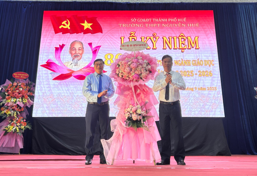 Ông Phạm Đức Tiến, Phó Bí thư Thường trực Thành ủy Huế (phải) tặng hoa chúc mừng tập thể Trường THPT Nguyễn Huệ. 2d18210f-c0ff-4d02-98a4-19fa2f8c3797.jpg