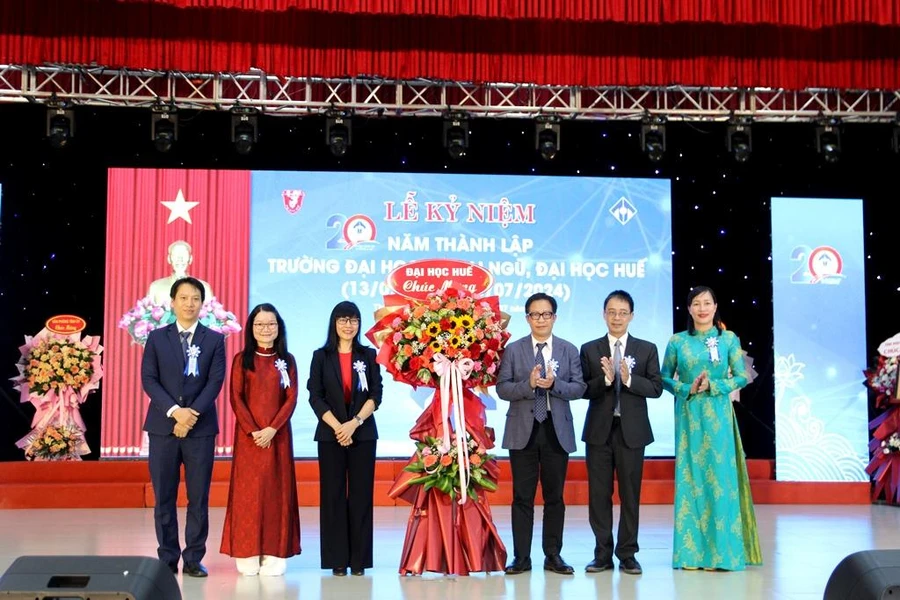 Lãnh đạo Đại học Huế (phải) tặng hoa chúc mừng Ban Giám hiệu Trường Đại học Ngoại ngữ, Đại học Huế (trái) tại lễ kỷ niệm 20 năm thành lập trường. (Ảnh: Đại Dương)