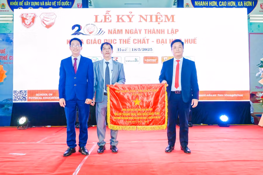 Lãnh đạo Khoa Giáo dục Thể chất - Đại học Huế (bên trái) đón nhận Cờ thi đua của Bộ GD&ĐT vì thành tích tiêu biểu xuất sắc. (Ảnh: Bùi Ngọc Lân)