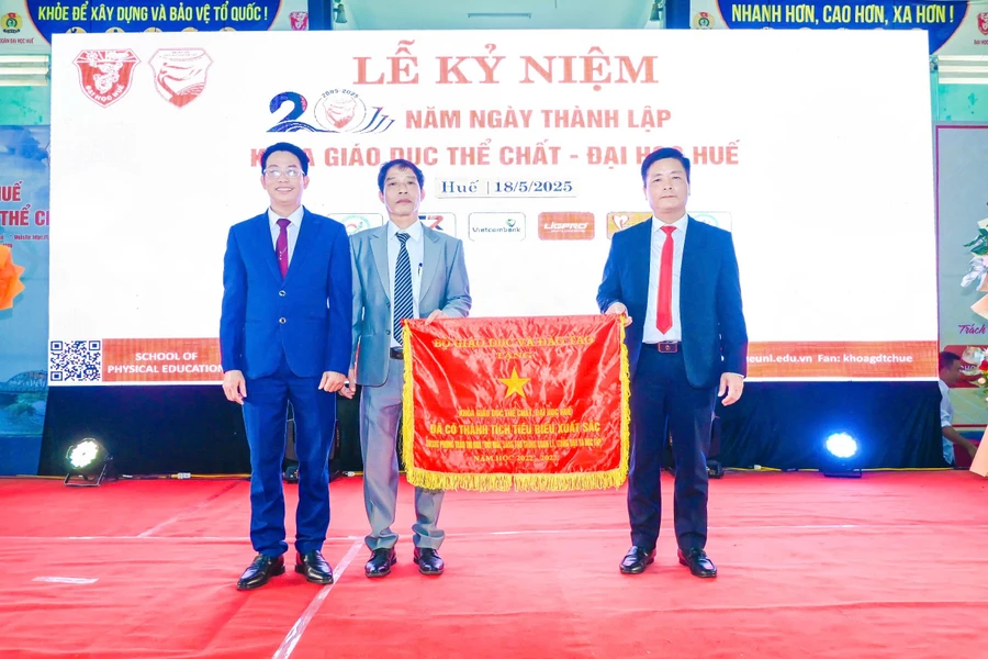 Lãnh đạo Khoa Giáo dục Thể chất - Đại học Huế (bên trái) đón nhận Cờ thi đua của Bộ GD&ĐT vì thành tích tiêu biểu xuất sắc. (Ảnh: Bùi Ngọc Lân)