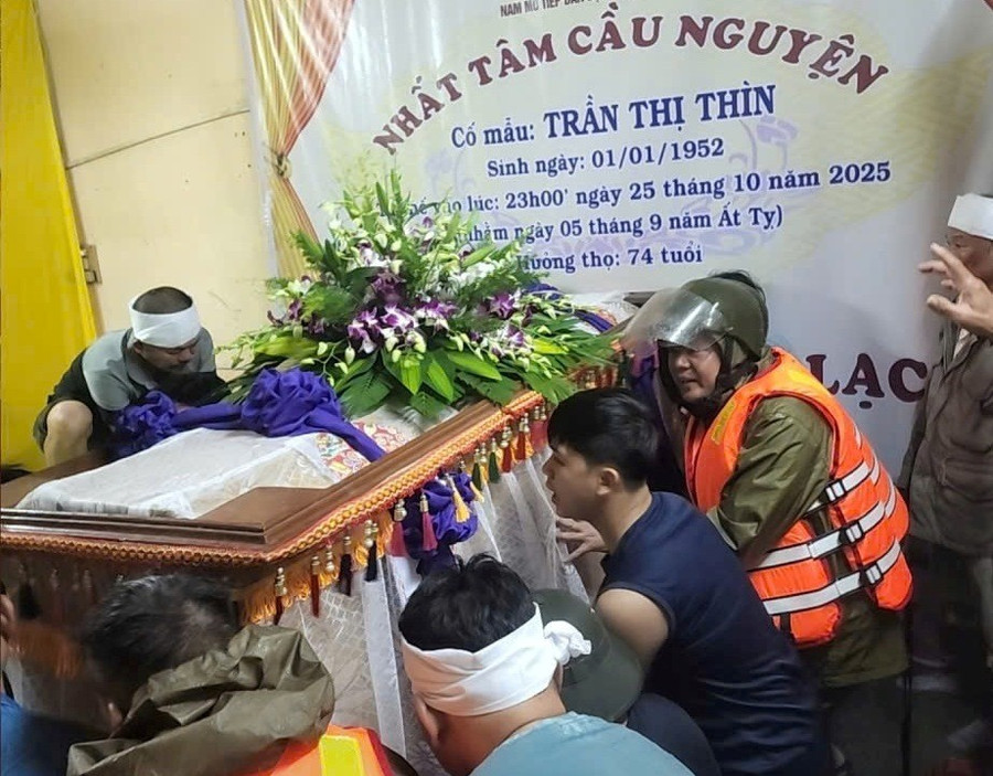 Lực lượng công an phụ giúp cùng gia đình khiêng quan tài lên chỗ cao ở phường Phú Xuân. z7160223424879-7bb61a325ec44800cd77b9eea970a983.jpg