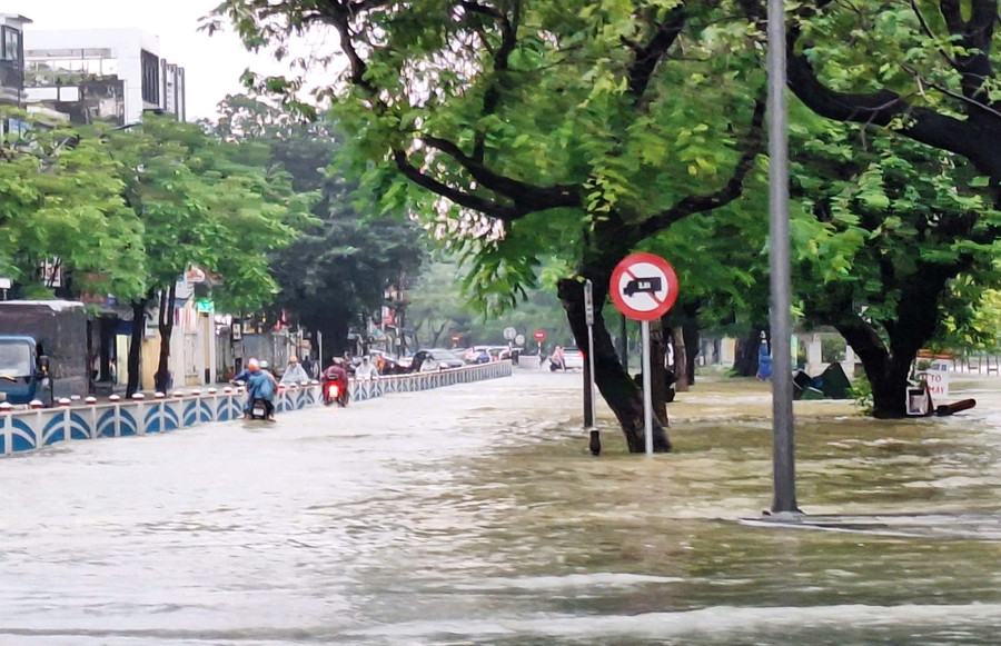 Đường Trần Hưng Đạo, đoạn gần cầu Phú Xuân bị nước lũ từ sông Hương dâng qua tràn đường, các phương tiện vẫn cố đi lại rất nguy hiểm. z7159217851759-99006a86e2d48c210fff1a5f29703e15.jpg