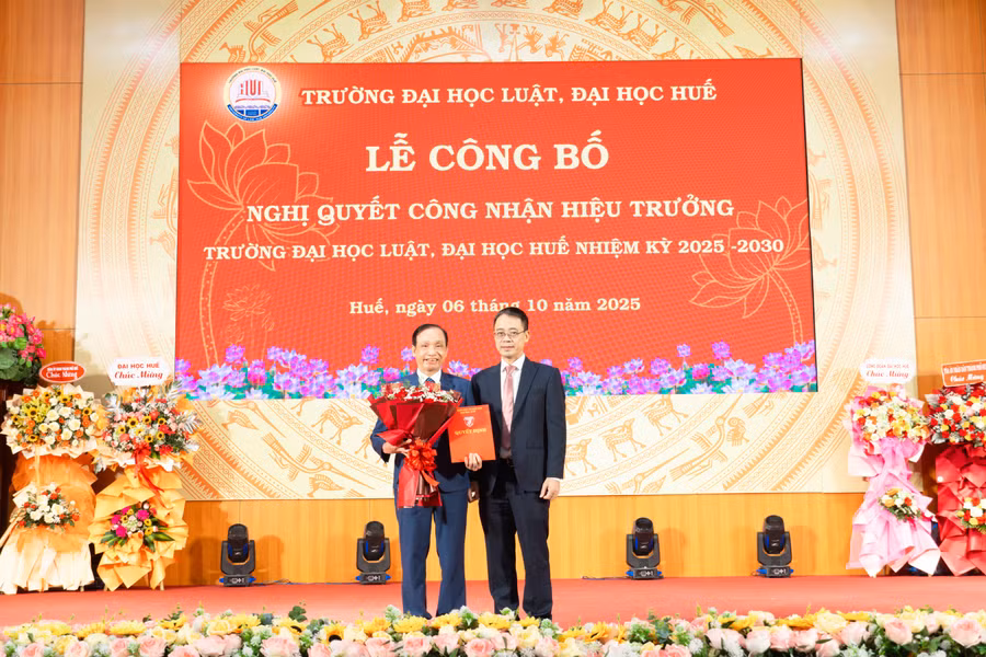 PGS.TS Đoàn Đức Lương (trái) nhận Nghị quyết công nhận Hiệu trưởng Trường Đại học Luật nhiệm kỳ 2025-2030.