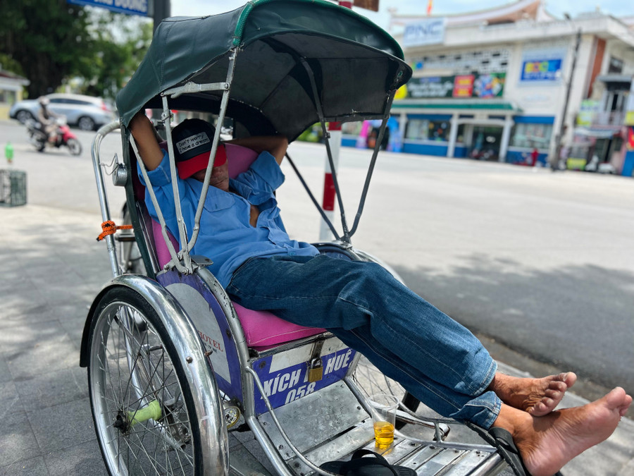 Chú xích lô tranh thủ ngả lưng ngay bên đường để tiện chủ động công việc. anh-11.jpg