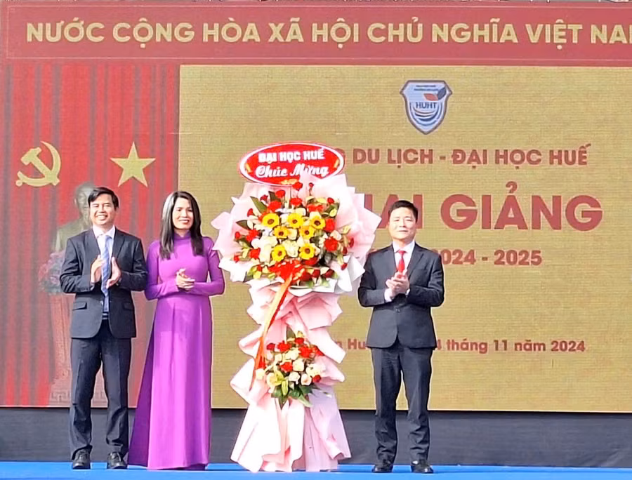 TS Bùi Văn Lợi, Phó Giám đốc Đại học Huế (bìa phải) tặng hoa chúc mừng Ban Giám hiệu Trường Du lịch - Đại học Huế tại lễ khai giảng. (Ảnh: Đại Dương)